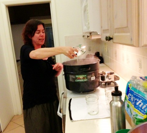 Lisa Fulk, certified master food preserver, carefully removes hot sterilized jars from the canner.