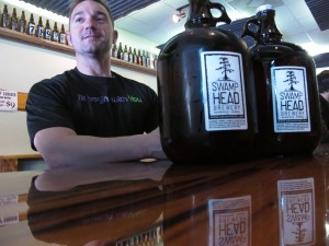 Adam Rudell, of St. Petersburg, Fla., sits with two gallon-sized jugs of beer, known among beer enthusiasts as growlers, at the Swamp Head Brewery in Gainesville, Fla., in March. (AP Photo / Brendan Farrington)