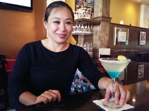 Thuy Nguyen poses with the blueberry vodka drink she created, the Crystal Blue Persuasion, at Patrick's 1481 in downtown Sarasota. STAFF PHOTO / WADE TATANGELO