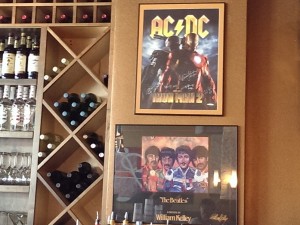 A poster signed by the members of AC/Dc, including lead singer and Sarasotan Brian Johnson, hangs behind the bar at Patrick's 1481 along with an illustration of The Beatles by Sarasota-based painter William Kelley. STAFF PHOTO / WADE TATANGELO