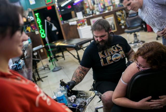 Tattoo artist TJ Connors works on Jenna Harmon's first tattoo at the Southern Hellfire Electric Tattoo studio in Sarasota in January. (Staff photo / Nick Adams)