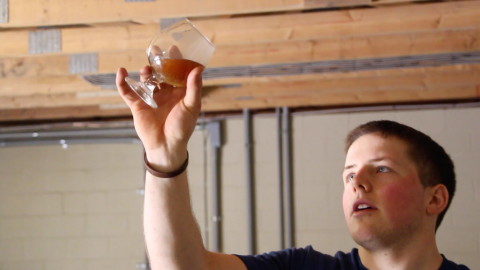 Brandon Capps, head brewer at Braddock, Pennsylvania, startup The Brew Gentlemen, examines wort in a scene from the documentary "Blood, Sweat, & Beers." (Provided by Alexis Irvin)