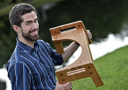 FSU/Asolo Conservatory student Wes Tolman displays his Tao Bamboo adjustable Squatty Potty that sells for $80. Hand-made from renewable bamboo, it is one of several styles available for the bathroom helper. (October 13, 2015; STAFF PHOTO / THOMAS BENDER)
