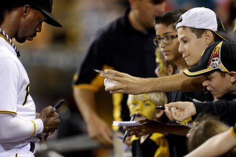 Pittsburgh Pirates center fielder Andrew McCutchen, left, gives autographs before a baseball game.  (AP Photo/Gene J. Puskar)