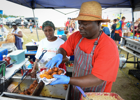 Sonza Bullard watches as Mustafa Shaeazz puts an order together from their booth Taste and Tell Saturday. April 29 at the Suncoast BBQ and Bluegrass Bash.   (April 19, 2014) (Herald-Tribune staff photo by  Rachel S. O'Hara)