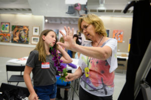 Loreen Kaspersch helps Gabrielle Kozel, 10, come up with ways to add flowers to Kozel's dress Monday, July 25 during Art Center Sarasota's iConcept Jr. summer camp. STAFF PHOTO / RACHEL S. O'HARA