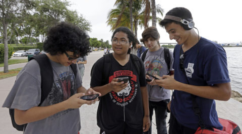 Pokemon Go players check their smartphones as they try to find Pokemon at Bayfront Park in downtown Miami. AP PHOTO / ALAN DIAZ